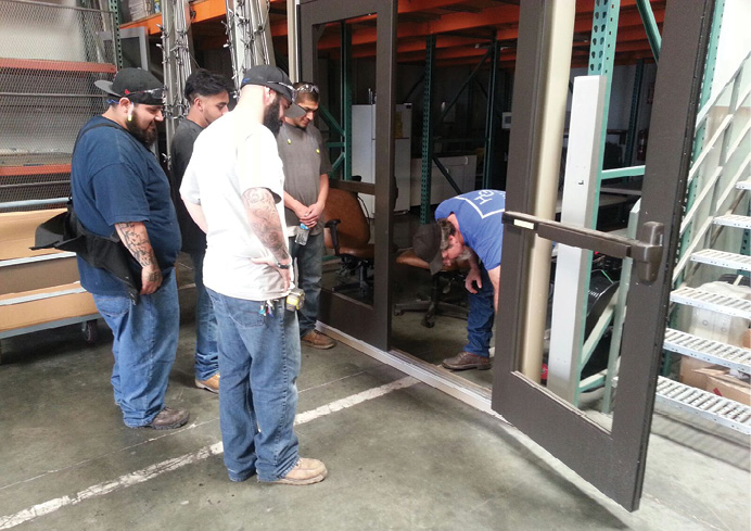 Hale Glass, haleglass.com, runs a yearly five-week training program, Teach Our People. Here, employees learn how to hang doors. The doors and jambs are in a permanent frame, and can be taken out and rehung as needed for training.