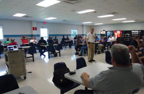 Greg Hultquist (standing), vice president of manufacturing at YKK AP, ykkap.com, conducts a quarterly communication meeting with all employees. 