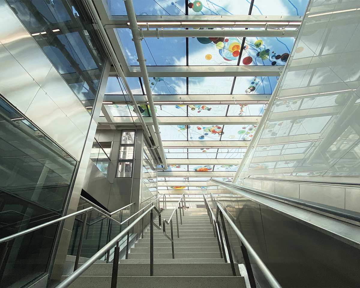 subway station stairway underneath glass floor providing natural light