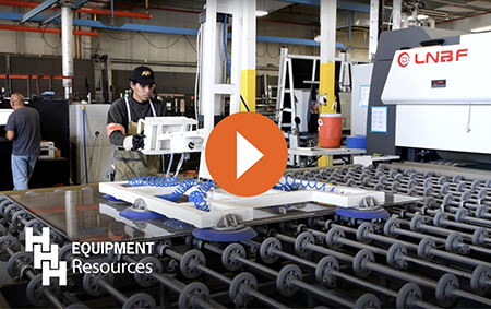 a worker operating the automatic laminated glass production line from hhh equiopment resources with a red play button in the center to activate the video