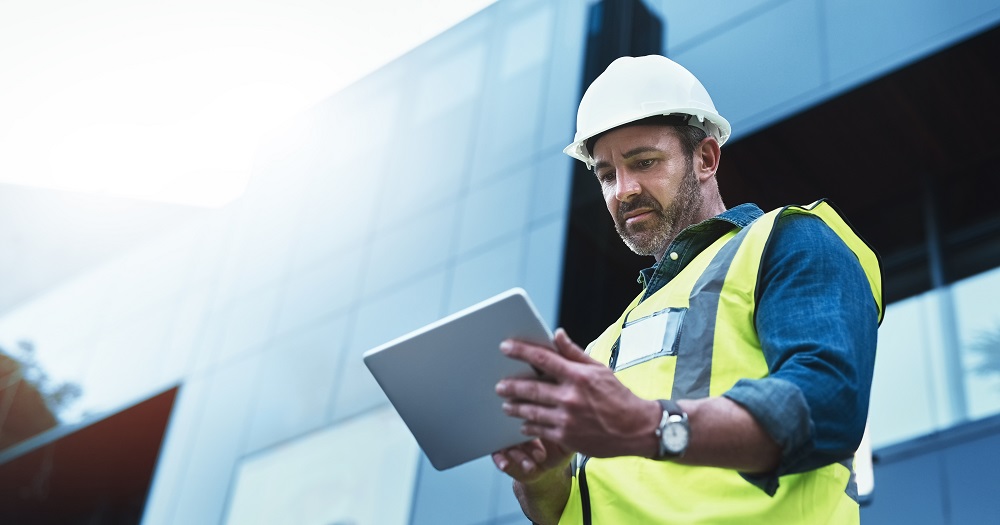 construction worker looks at a tablet on the jobsite