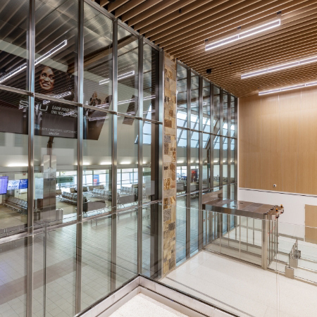 an interior view of a building with a several story glass curtain wall separating one rom from another