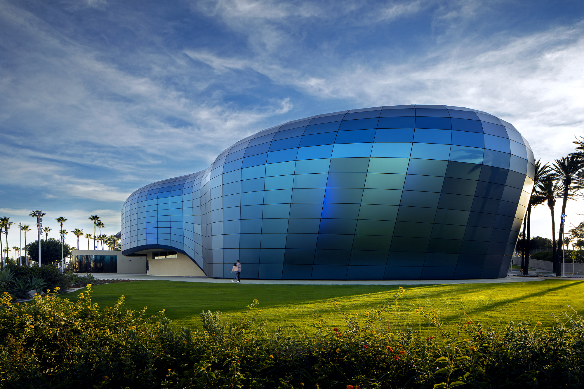 An ocean view greets patrons of the newly expanded Aquarium of the Pacific, thanks to a façade wrapped in reflective blue decorative glass, fabricated by Pulp Studio, with interlayers from Kuraray America.