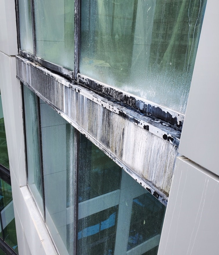 A metal system that has finish damage due to concrete runoff.