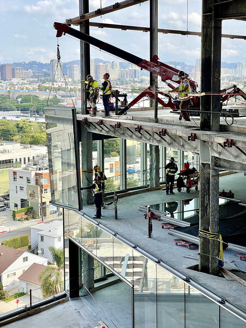 Glaziers install the glass facade of Lumen West.