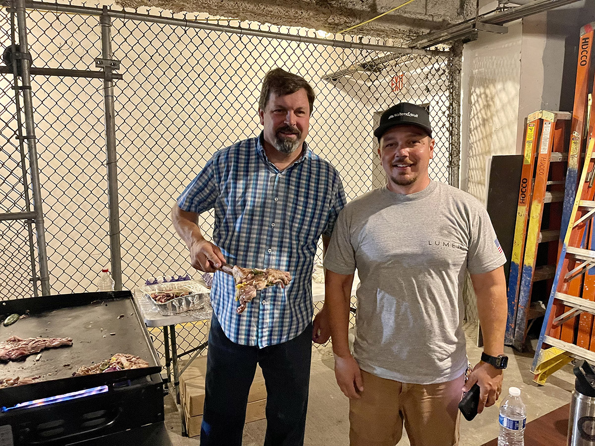 Matt Cowles of Hathaway Dinwiddie serves up a T-Bone steak to Charles Anderson of Walters & Wolf.