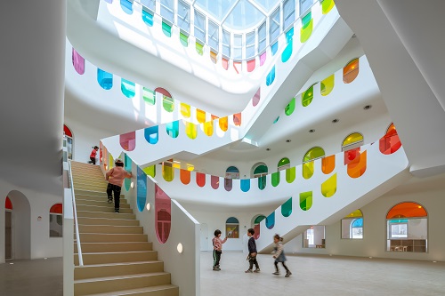 children playing on the stairs with multi-colored glass banisters