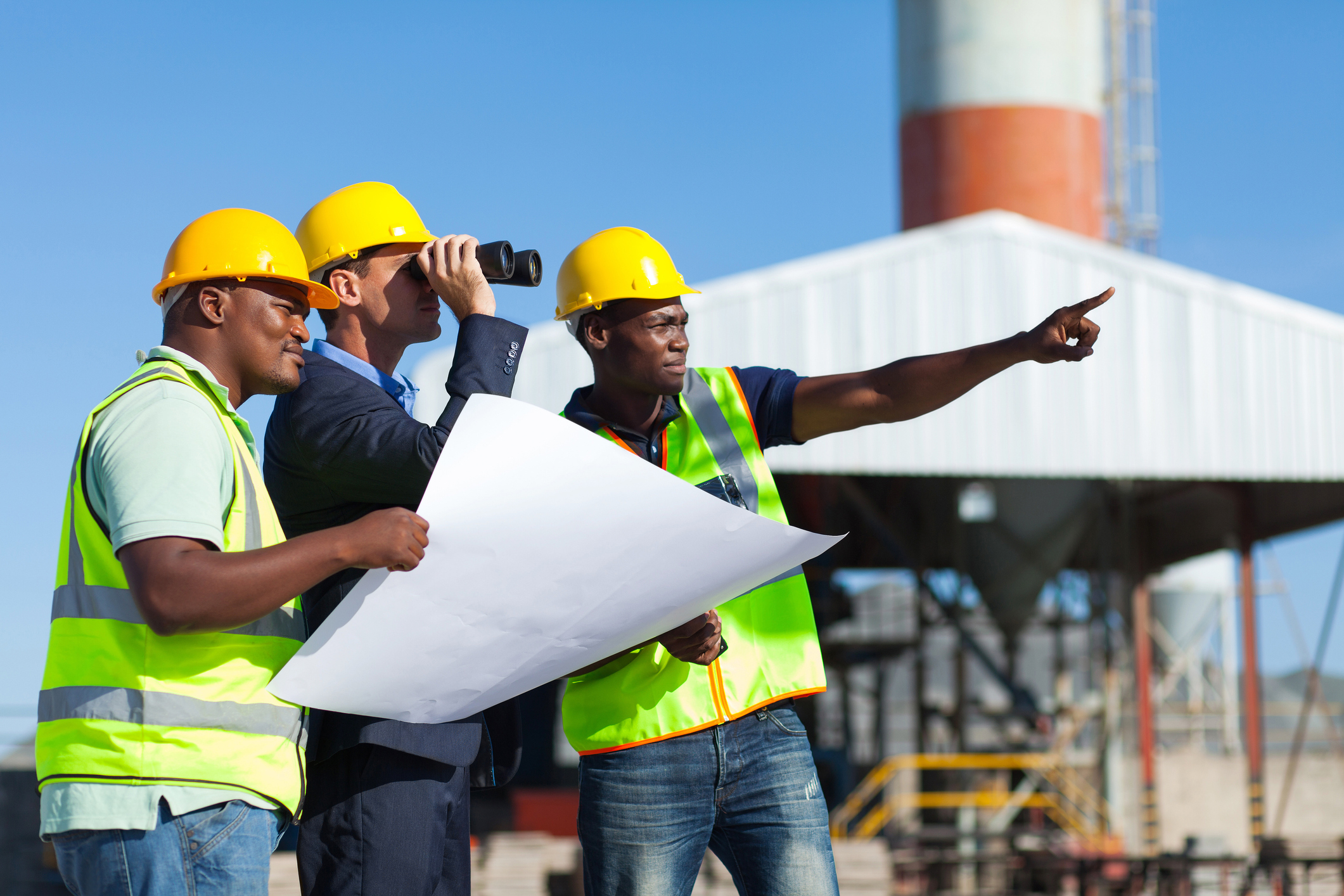 Stock image project manager visiting construction site with construction workers.