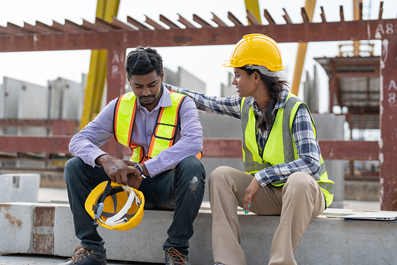 Construction worker comforting colleague