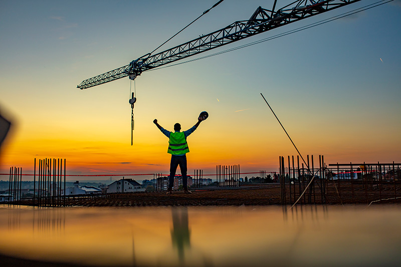 Construction worker in front of a sunrise