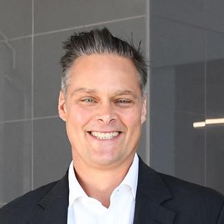 white man with salt and pepper spiked hair, smiling