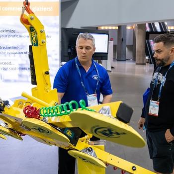 Representative from Wood's Powr-Grip demonstrates a lift to a GlassBuild attendee